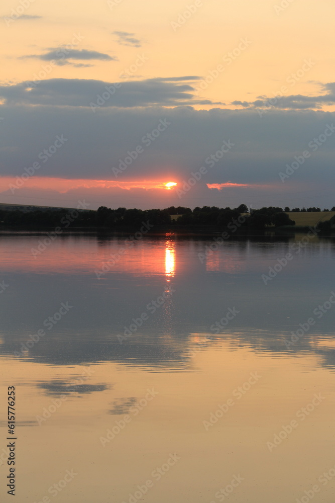 A body of water with text on it and a sunset in the background