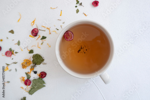 A cup of brewed herbal cranberry tea on a white background. View from above. The concept of proper nutrition, collection of herbs.