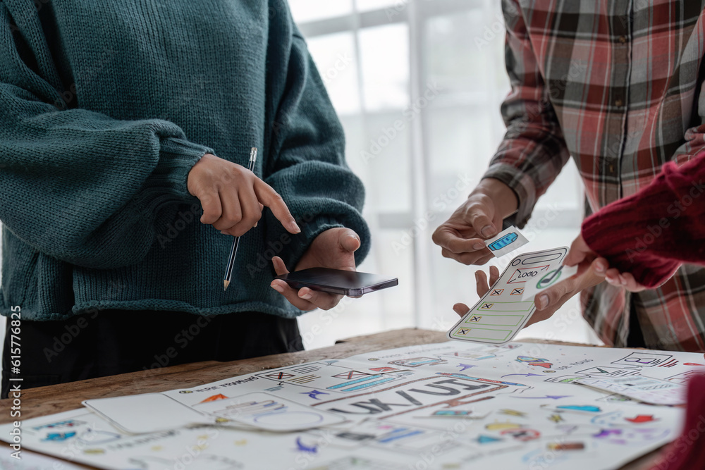 The web designer team is helping to design applications for mobile phones. UX UI designer concept The web designer team is helping to design applications for mobile phones. UX UI designer concept