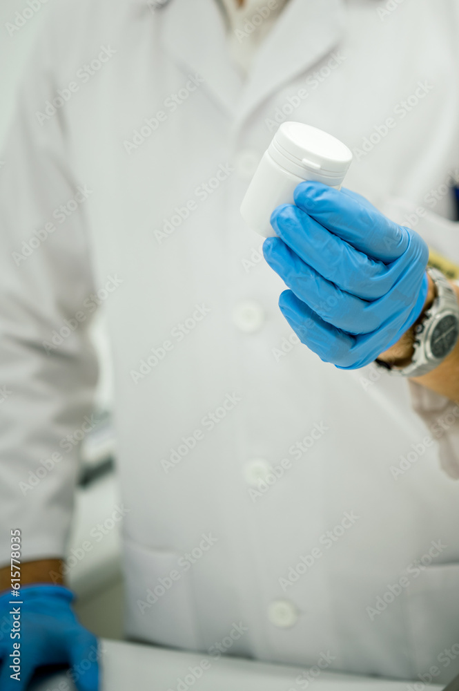 Crop pharmacist holding jar with pills in lab Crop pharmacist holding jar with pills in lab