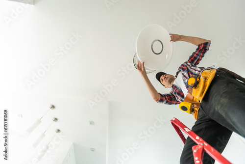 electrician installing led light bulbs in ceiling lamp