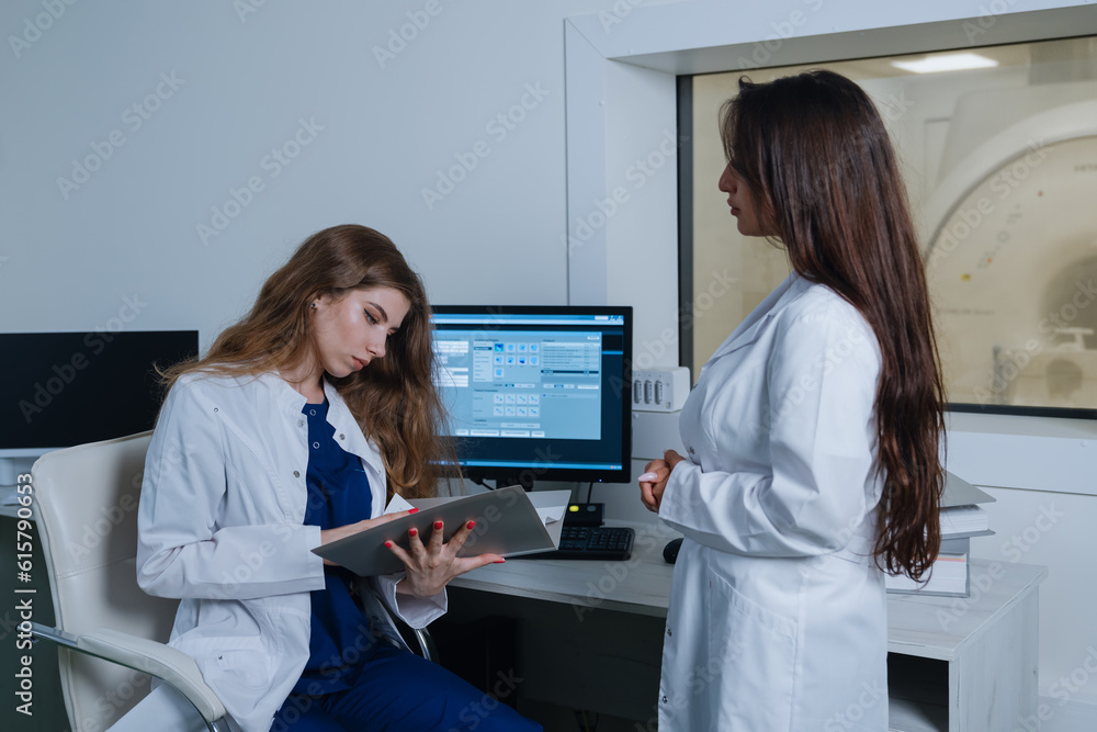 Φωτογραφία The nurse brought the woman doctor the patient's card to the radiologist's office