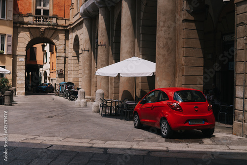 Fototapeta Naklejka Na Ścianę i Meble -  Red car in front of a building in Bologna, Italy