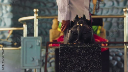 A view of a man circumambulating around the nandi or cow idol at a temple photo