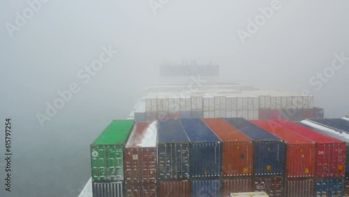 Pacific ocean - 02.06.2023 Ultra large container ship full of cargo containers passing through the snow storm in Pacific ocean during winter time. 