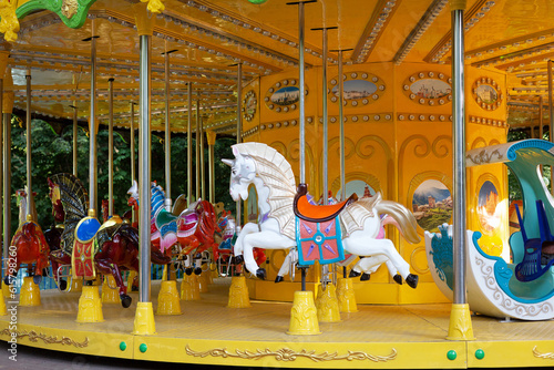 Merry carousel in city park in early morning. There is no one here. Carousels with horses waiting for children. Concept: joy and entertainment for children. Selective focus. May, 2023. Minsk, Belarus