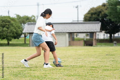 公園でサッカーをするアジア人の子供