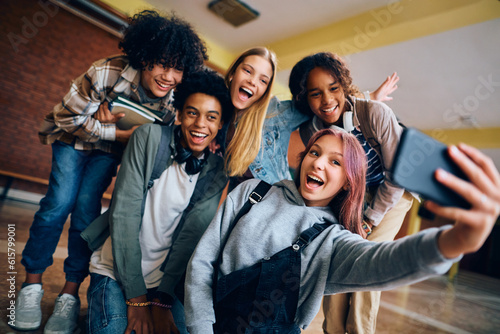 Cuadro en lienzo Multiracial group of cheerful teenage friends taking selfie at high school