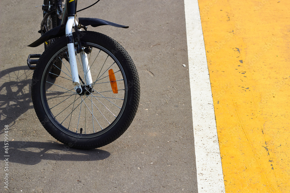 Close-up photo front wheel of bicycle on road. Close-up photo front wheel of bicycle on road.