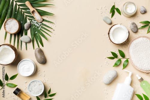 Coconut with jars of coconut oil and cosmetic cream on colored background. Top view. Free space for your text. Natural spa coconut cosmetics and organic treatment concept Coconut Spa composition photo