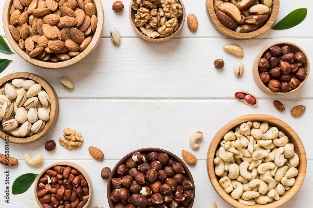 mixed nuts in wooden bowl. Mix of various nuts on colored background. pistachios, cashews, walnuts, hazelnuts, peanuts and brazil nuts mixed nuts in wooden bowl. Mix of various nuts on colored background. pistachios, cashews, walnuts, hazelnuts, peanuts and brazil nuts
