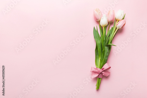 Fototapeta Naklejka Na Ścianę i Meble -  Bouquet of pink tulips on colored table background . Top view with copy space. Waiting for spring. Happy Easter card. Flat lay