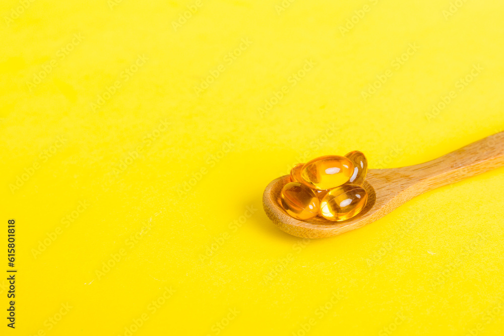 Vitamin omega capsules in a spoon on a colored background. Pills served as a healthy meal. Red soft gel vitamin supplement capsules on spoon Vitamin omega capsules in a spoon on a colored background. Pills served as a healthy meal. Red soft gel vitamin supplement capsules on spoon