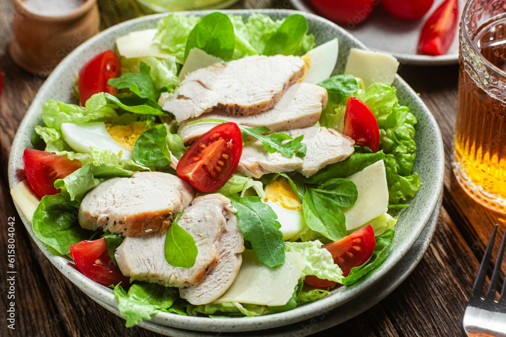 Salad of chicken fillet, eggs, tomatoes and cheese in a plate. Caesar salad Salad of chicken fillet, eggs, tomatoes and cheese in a plate. Caesar salad