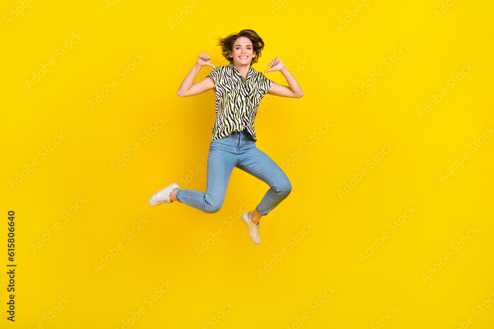 Full length photo of funky cool lady wear animal print shirt pointing herself thumbs jumping high isolated yellow color background