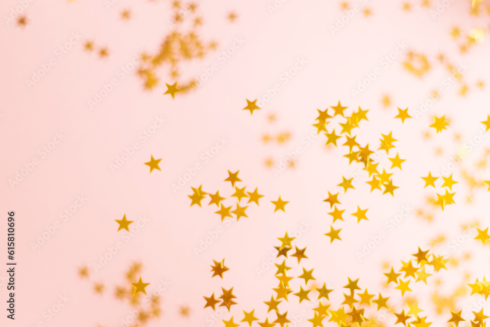 Pink background and gold confetti in the shape of stars. Beautiful holiday glitter Pink background and gold confetti in the shape of stars. Beautiful holiday glitter