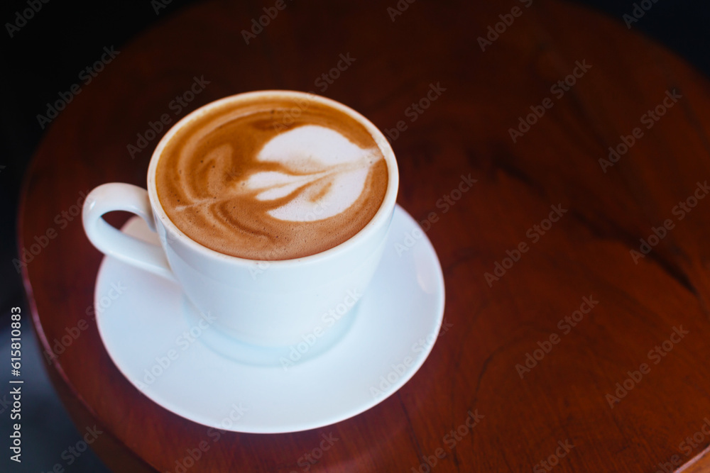 Cappuccino with foam in a white mug on a wooden table. Coffee on a dark atmospheric background. Stylish hot drink concept Cappuccino with foam in a white mug on a wooden table. Coffee on a dark atmospheric background. Stylish hot drink concept