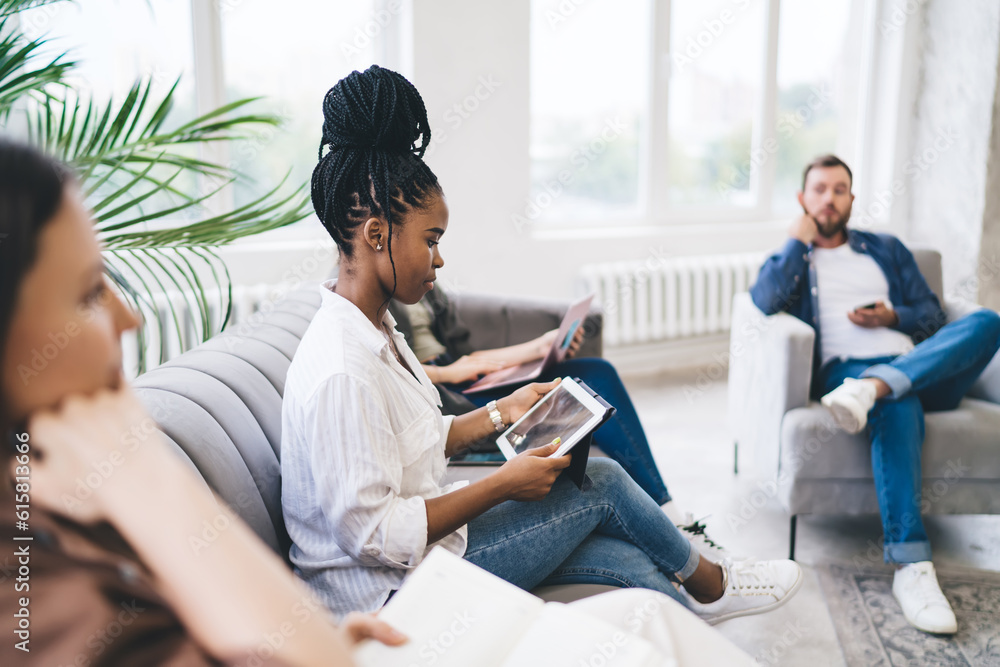 Cheerful diverse colleagues working on project sitting together at office Cheerful diverse colleagues working on project sitting together at office