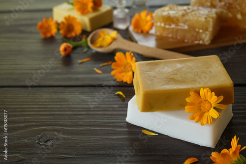 Natural handmade soap with calendula (pot marigold), oil essential and honeycomb on rustic wooden background. Healthy skin care. SPA concept. photo