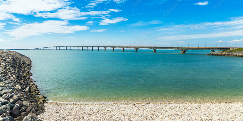Fototapeta premium Ile de Ré bridge seen from La Rochelle seashore on a sunny day in Charente-Maritime, France