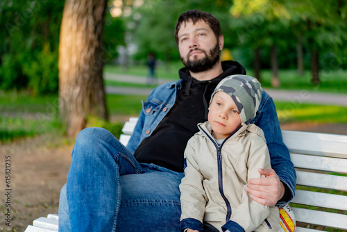 Caucasian bearded man with his little son in park. Image with selective focus