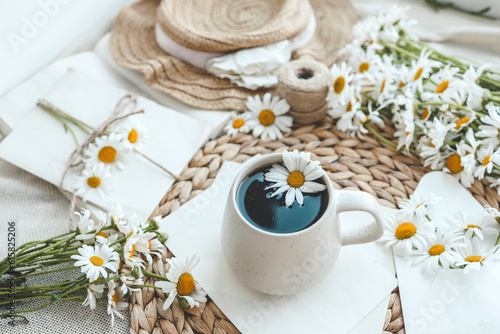 Vintage still life on the windowsill, a cup of tea and a bouquet of daisies