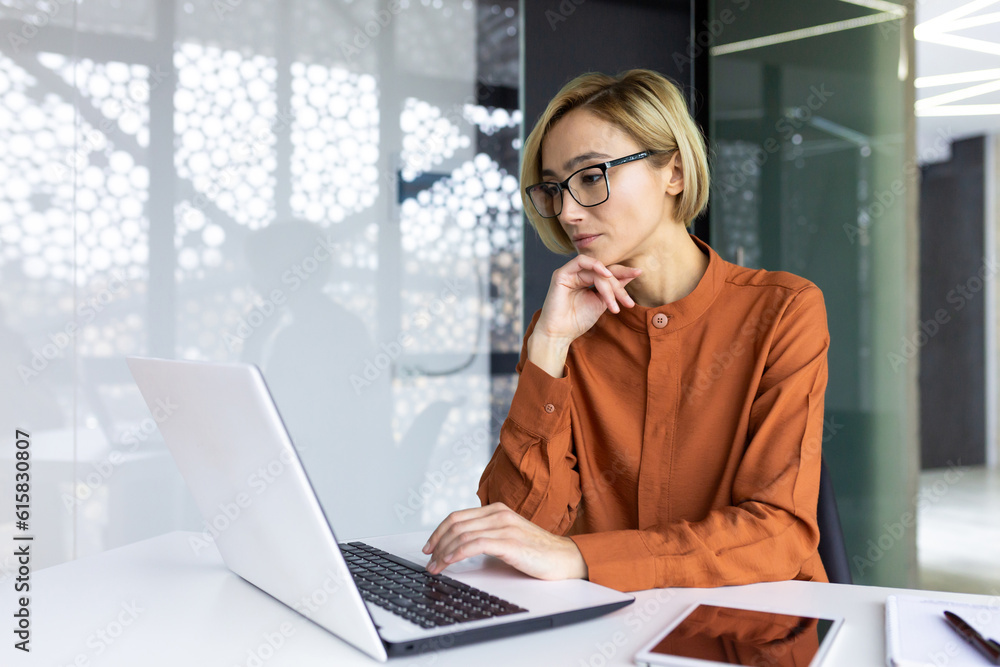 Serious thinking woman working with laptop inside office at workplace, businesswoman solving technical task, female programmer coding new software. Serious thinking woman working with laptop inside office at workplace, businesswoman solving technical task, female programmer coding new software.