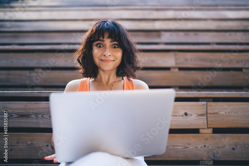 Surprised woman using laptop while studying online photo