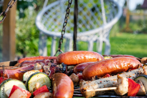 barbecue with delicious grilled sausages and vegetables on grill outdoors
grill z pysznymi grillowanymi kiełbaskami i warzywami na grillu na świeżym powietrzu
 photo