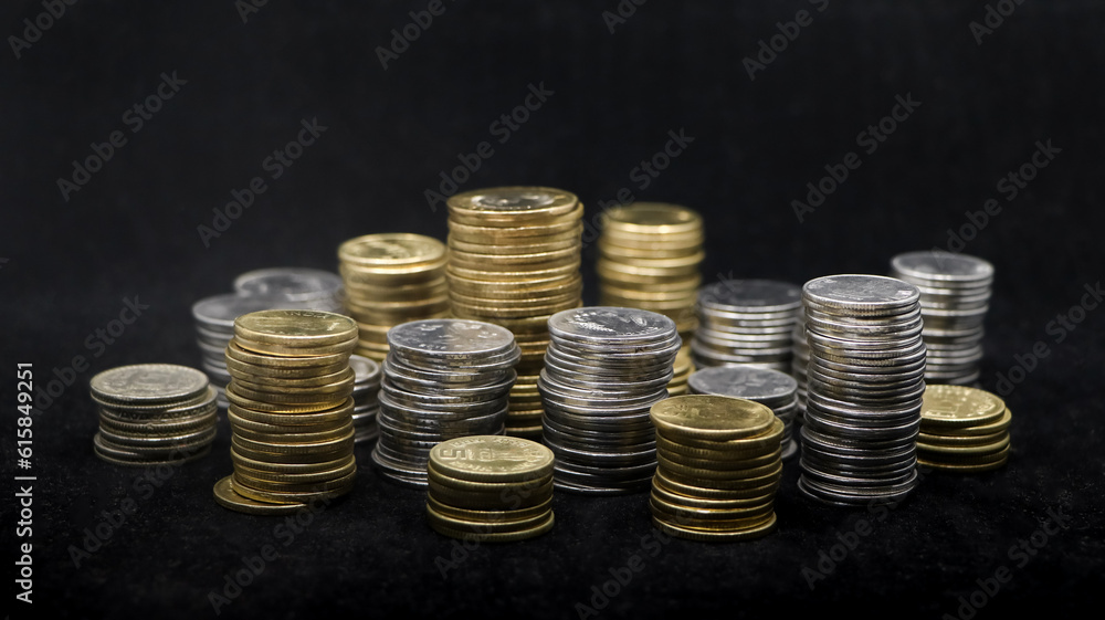 closeup shot of rows of gold and silver coins arranged and stacked in towers of different size isolated in a black background closeup shot of rows of gold and silver coins arranged and stacked in towers of different size isolated in a black background