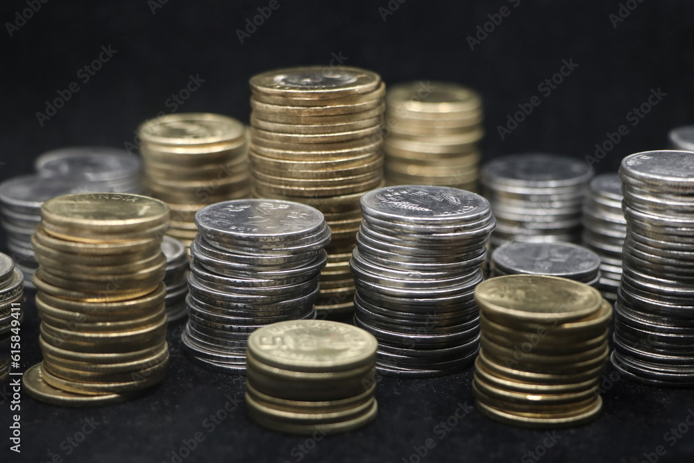 closeup shot of rows of gold and silver coins arranged and stacked in towers of different size isolated in a black background closeup shot of rows of gold and silver coins arranged and stacked in towers of different size isolated in a black background