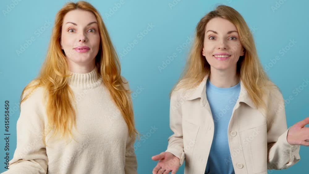 Friends, surprised woman and hands up wonder, shocked. Wow! Two women fashionable sister Amazed screaming excited by success, win. Triumph surprise emotion, studio shot isolated on blue background