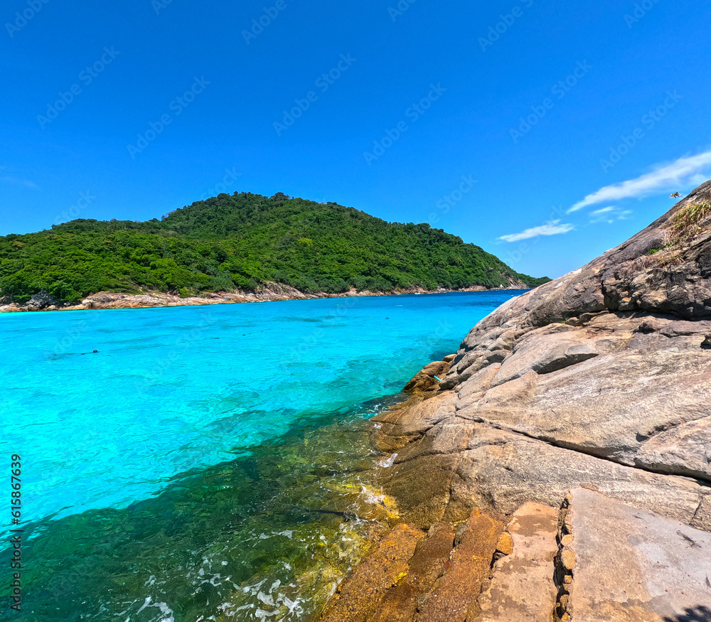 Kho Rasha island off the coast of phuket thailand by speed bias from Chalong Bay, beautiful turquoise Blue beach with white soft sand and lush green trees 