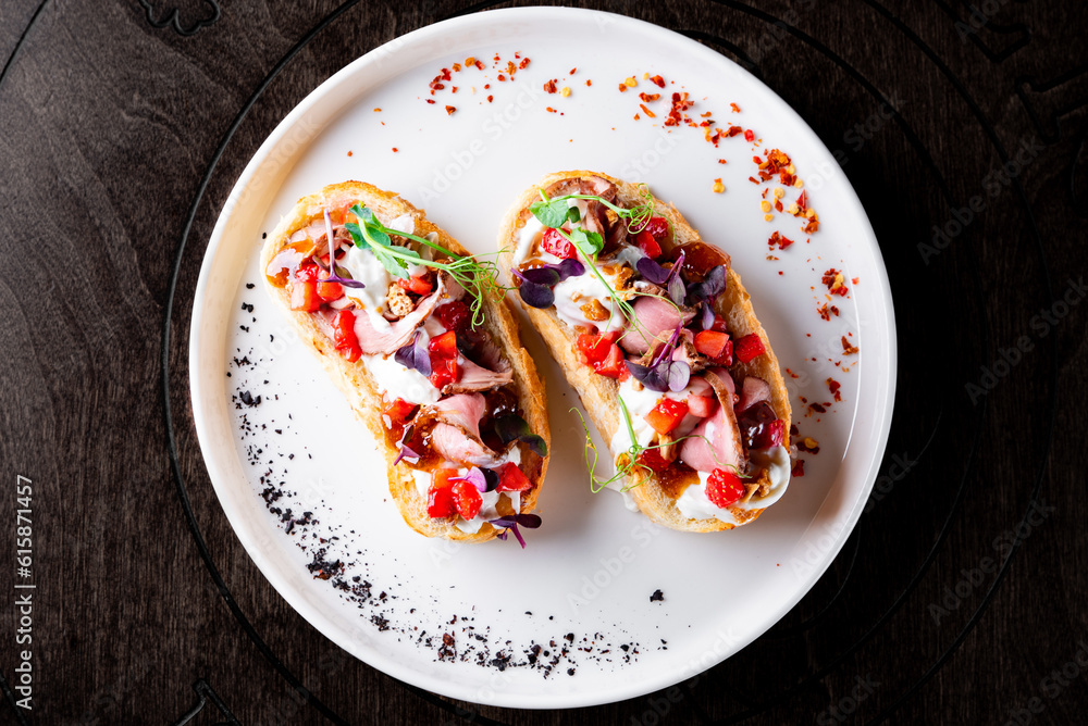 Strawberry bruschetta with duck meat, goat cheese on plate