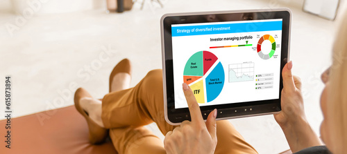 Strategy of diversified investment. Investor managing portfolio. Pie chart and candlestick charts.  photo