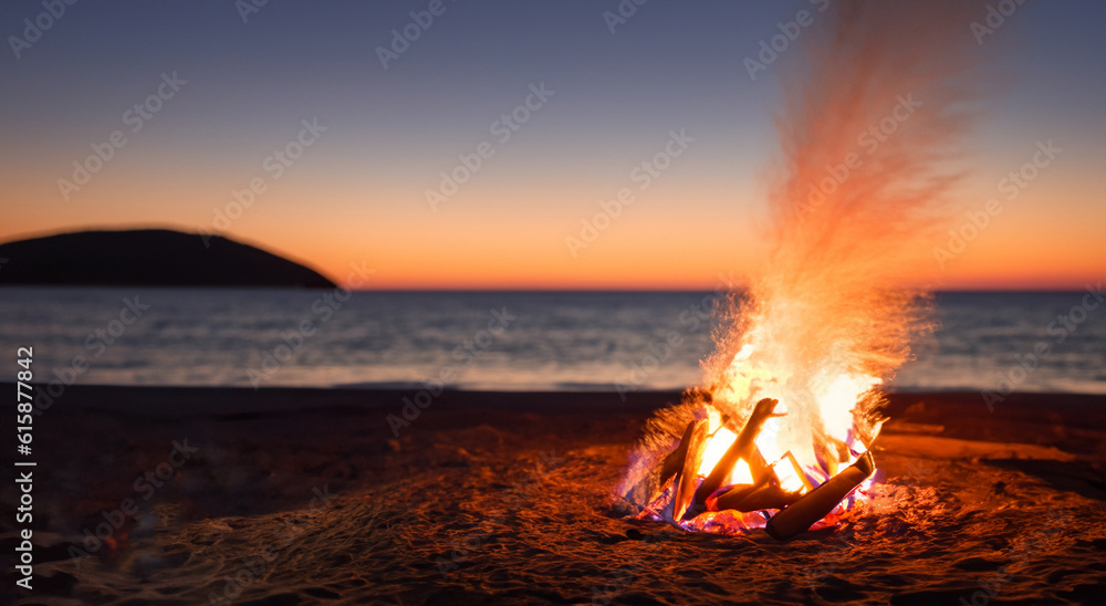 Obraz premium beautiful campfire in the middle of a nice beach with a beautiful sunset