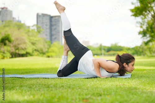 Pleasant millennial woman practice yoga outdoor in the morning during wellness retreat.