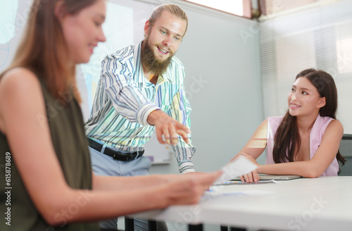 Young office worker presenting new financial plan to his partners during a meeting