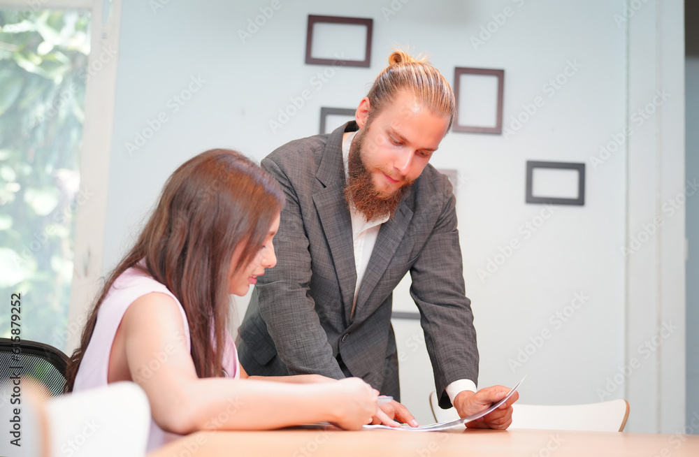 Young office worker presenting new financial plan to his partners during a meeting Young office worker presenting new financial plan to his partners during a meeting