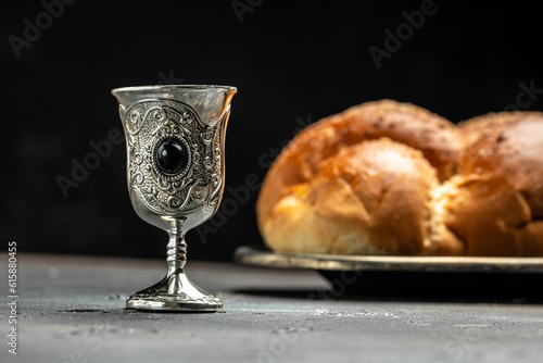 Shabbat Shalom challah bread, shabbat wine on a dark background, place for text, top view photo