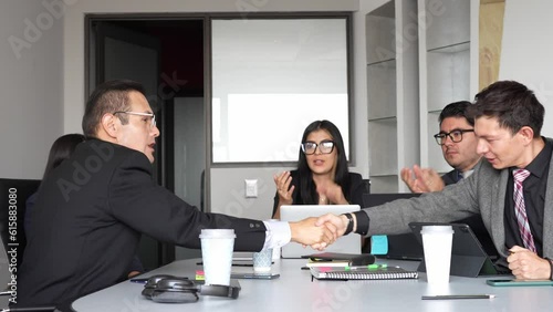 businessmen shaking hands with mixed group applausing, closing a contract, Business professionals exchanging handshakes amidst a diverse audience applauding photo