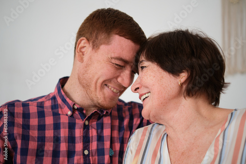 Intergenerational love: caring son embraces happy mother, cherishing cherished moments. Mature woman enjoys sincere trust with adult child at home