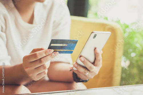 Woman hand using smart phones and holding credit card for shopping payment online, or for business, finance, and payment concepts.