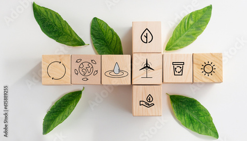 sustainable resources symbols on wooden cube for renewal energy systems with leaves background photo