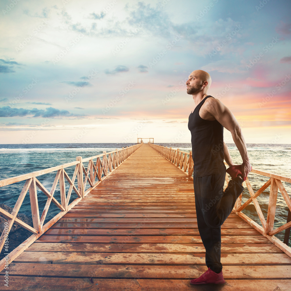 Fototapeta premium Stretching and exercises of gymnastics on a pier at sunset with sea landscape