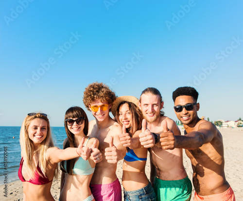 Happy group of friends having fun on the beach. Concept of summertime
