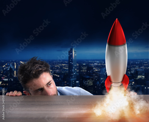 Fototapeta Naklejka Na Ścianę i Meble -  Businessman holding a small rocket. Startup of a new company concept