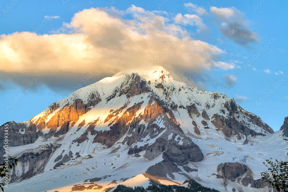 Mount Hood and clouds over mountain top peak during summer closeup