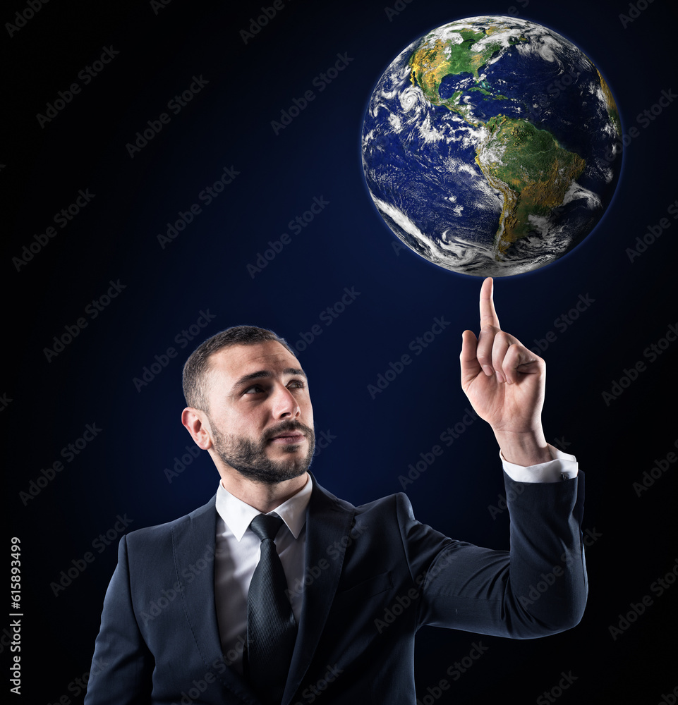 Successful businessman holds the world with a finger. World provided by NASA Successful businessman holds the world with a finger. World provided by NASA