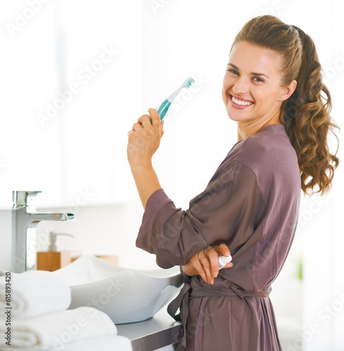 Portrait of smiling woman with toothbrush in bathroom